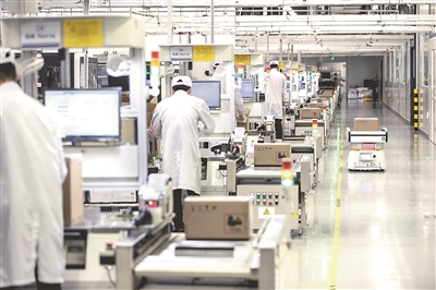 图为位于广东省东莞市的华为生产基地内，工作人员正在操作先进的生产设施。（图片来源：视觉中国）