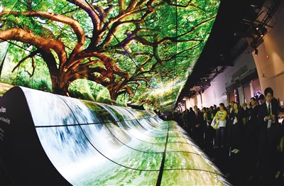 1月8日,LG公司的巨型曲面屏亮相美国拉斯维加斯消费电子展。LG Display(LGD)专家吕相德在接受第一财经记者专访时介绍说,LG的可卷曲电视预计在2019年年底正式推向市场。 新华社图